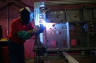 Worker Welds Metal Cabinet